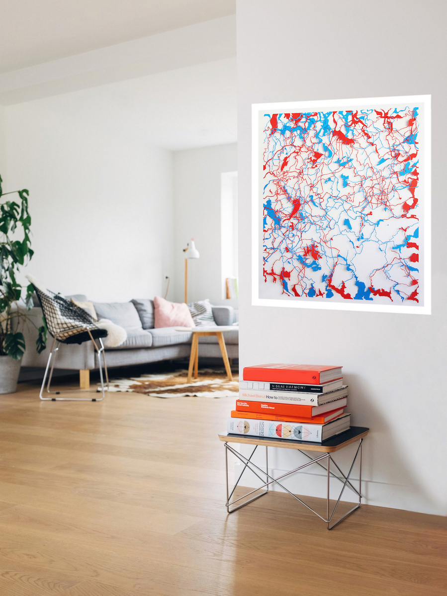 Contemporary art in-situ in sunny living room, grey sofa, white walls. Body of Water by artist Di Allison HALLISON Studios.Tasmanian rivers as cut paper of blue & red, white background. Suggests body's circulatory system. Glover Art Prize finalist