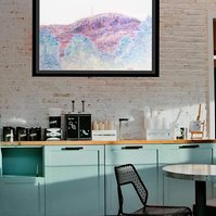 In-situ contemporary art in a kitchen. Diane Allison, HALLISON Studios, Tasmania. Business stamps eg not negotiable, urgent, paid, fragile, on paper, shaped like Kunanyi Mt. Wellington in blue, red, green, black - environmental art, cable car debate.  