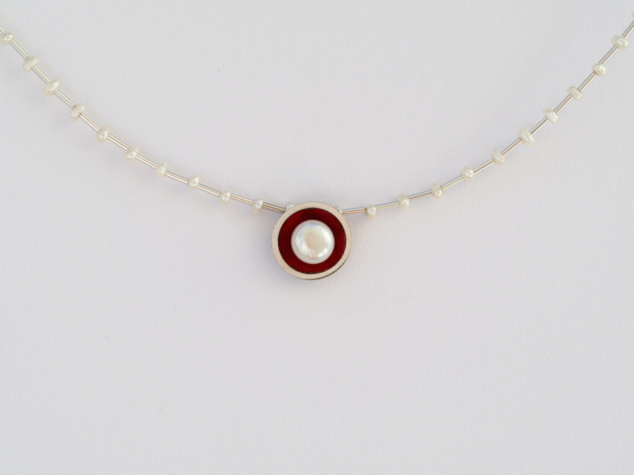 Classic and contemporary connect in this round sterling silver and kiln fired red vitreous enamel pendant, set with a round luminous freshwater pearl.  Made by jeweller Diane Allison, HALLISON Studios, Tasmania, from the Connect the Dots collection.