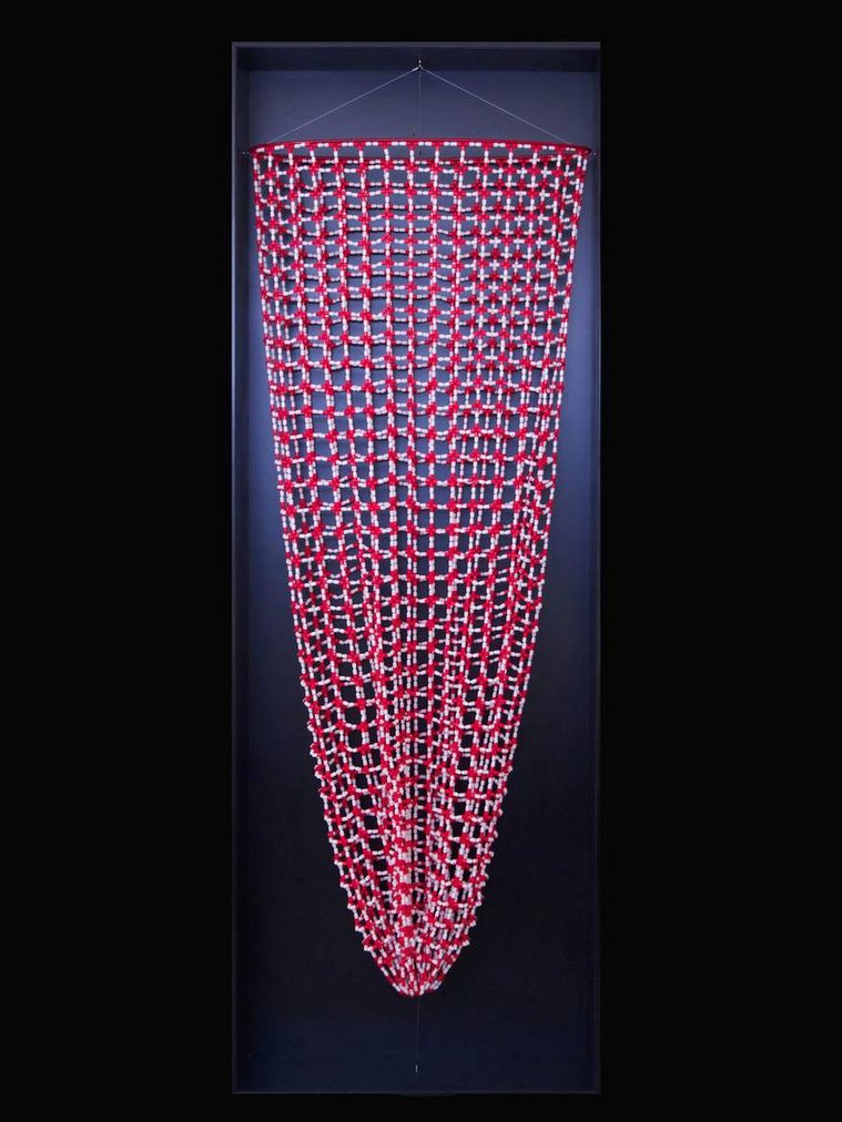 Safety Net by Tasmanian contemporary artist Di Allison, HALLISON Studios. A suspended artwork in the form of a large fishing net made using threaded empty red and white pill capsules, red thread