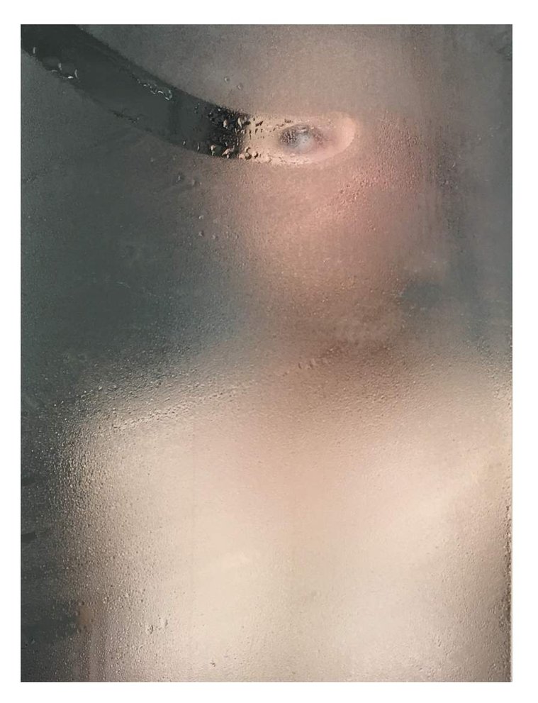 Fine art photography by Di Allison, HALLISON Studios, Tasmania, online gallery store. Self portrait in a mirror with condensation, water, drips on the glass, foggy. A streak on the glass reveals the woman's eye. Entitled The Looking Glass.