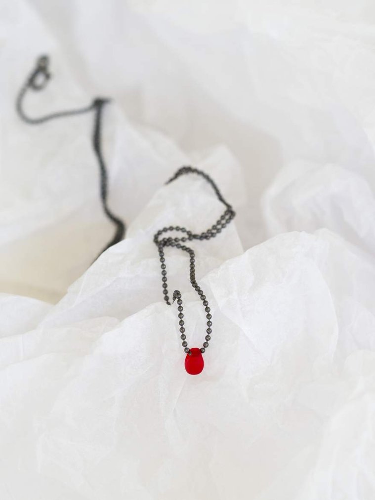 Inspired by the famous tale and speaks of love Sleeping Beauty pendant -  contemporary jewellery by Diane Allison HALLISON Studios Tasmania. Oxidised sterling silver chain with a single blood red droplet on a white textured background like snow or ice. 