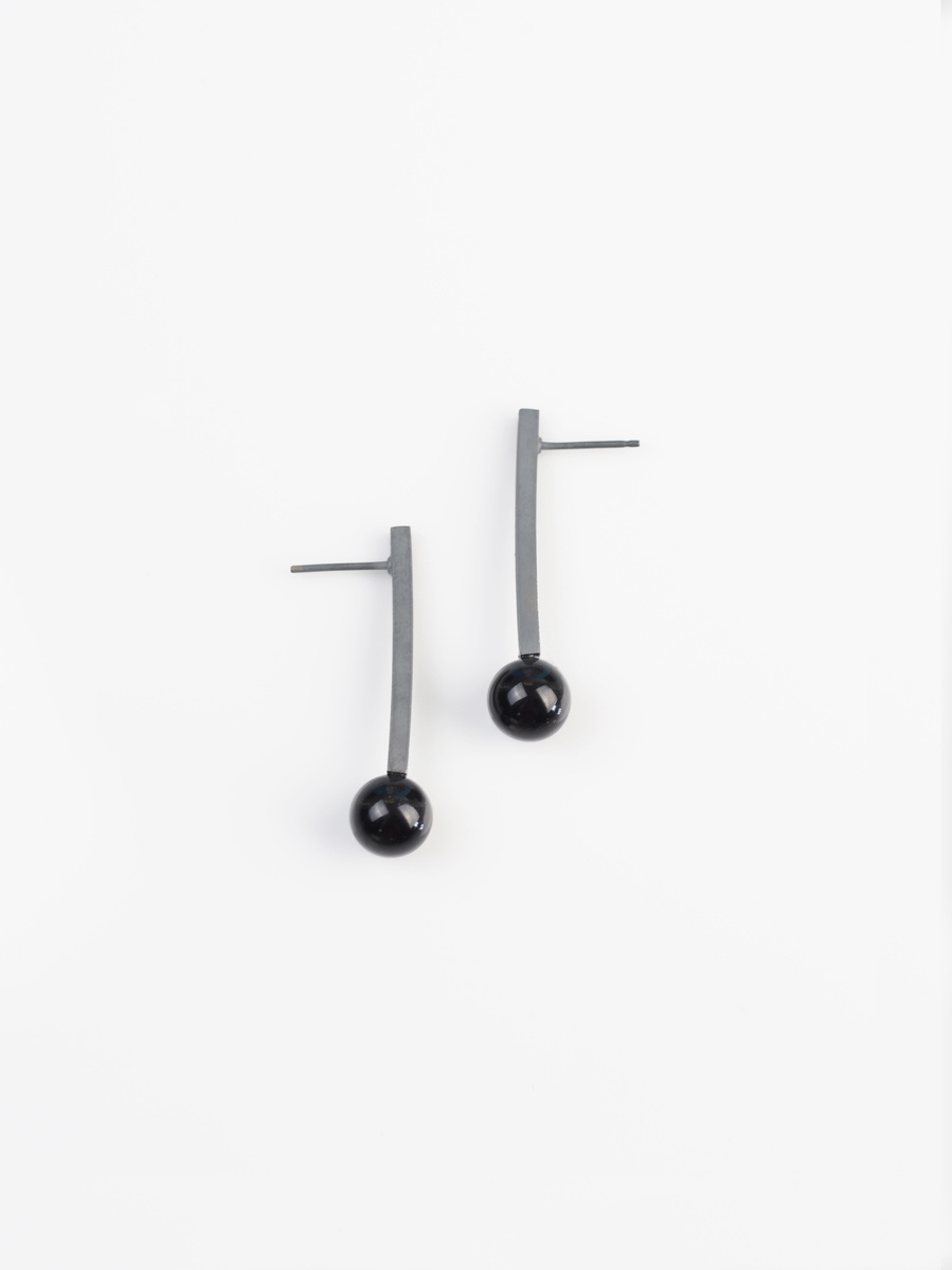 Oxidised sterling silver stem and black road agate stud earrings  by contemporary jeweller Di Allison of HALLISON Studios, Tasmania, entitled Exclamation!. The earrings are shaped like exclamation marks. 