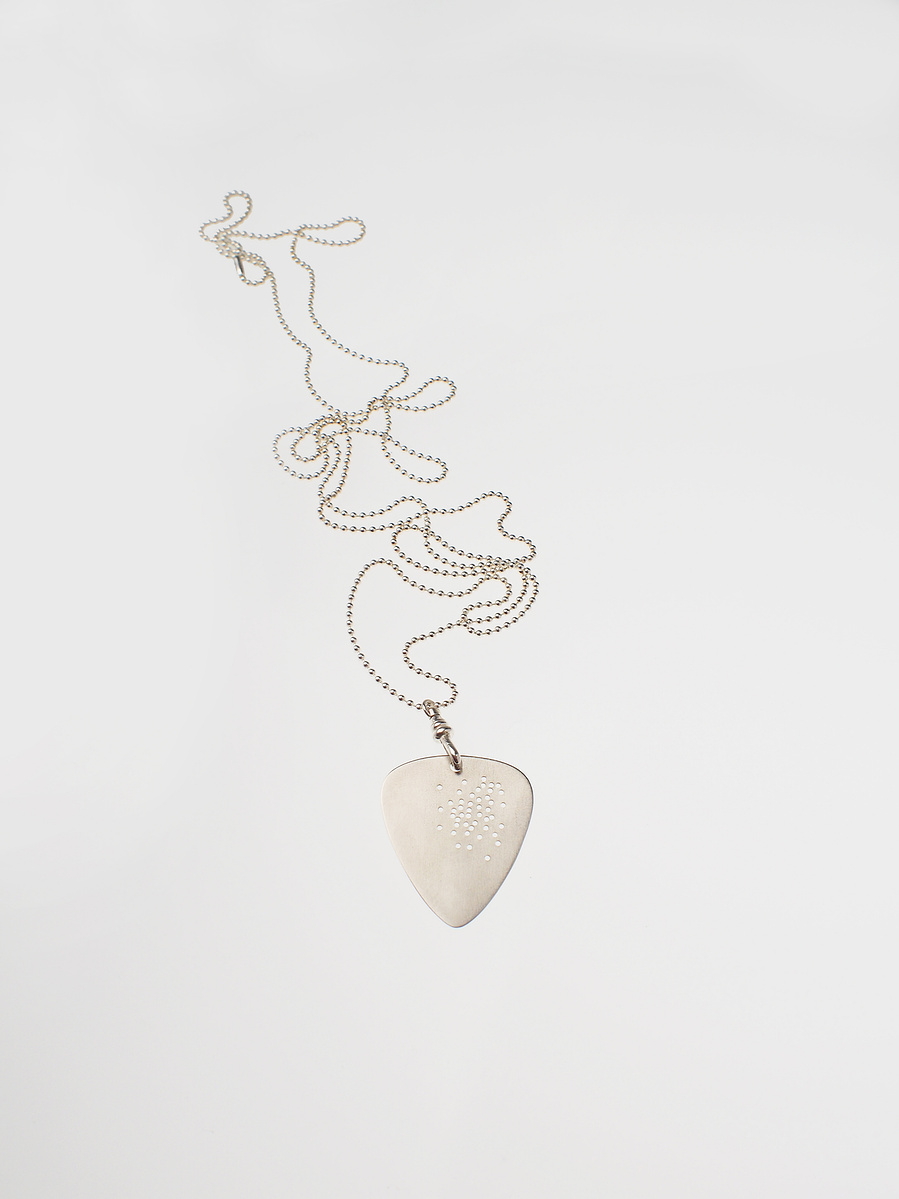 Wearable, detachable sterling silver guitar pick Shotgun Freckle the Road Signs from The Cruel Sea's This Is Not The Way Home song, on a dog tag style chain features numerous drill holes like tiny bullet holes. Made by jeweller Di Allison HALLISON Studios