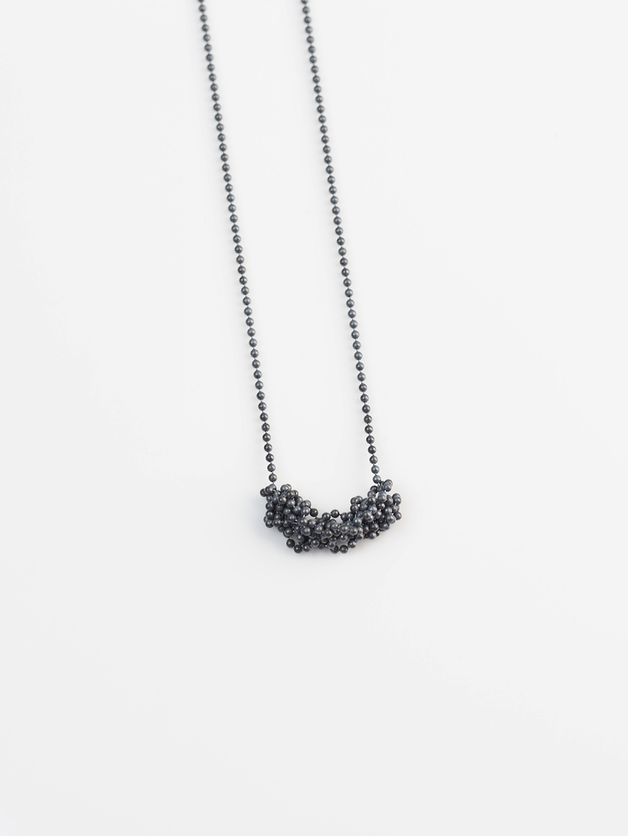 Handmade sterling silver pendant from the Knit 1 Purl 1 [K1 P1] series on a white background by contemporary jeweller Di Allison of HALLISON Studios, Tasmania. Features oxidised beaded sterling silver.