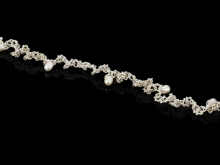 Knitted Pearls necklace, contemporary jewellery jewelry by Diane Allison, HALLISON Studios, online gallery store, Tasmania features white teardrop, droplet freshwater pearls entwined on bright sterling silver chain on a black background.