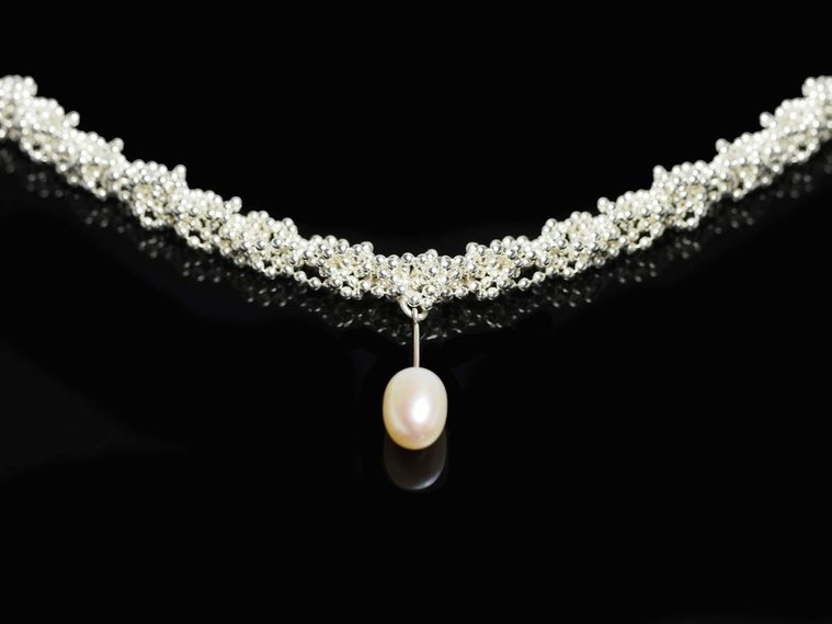 Knit 1 Purl1 K1P1 necklace by contemporary jeweller Di Allison, HALLISON Studios, Tasmania, online gallery store. This sterling silver handmade necklace features a white freshwater pearl droplet and is reminiscent of a DNA strand.