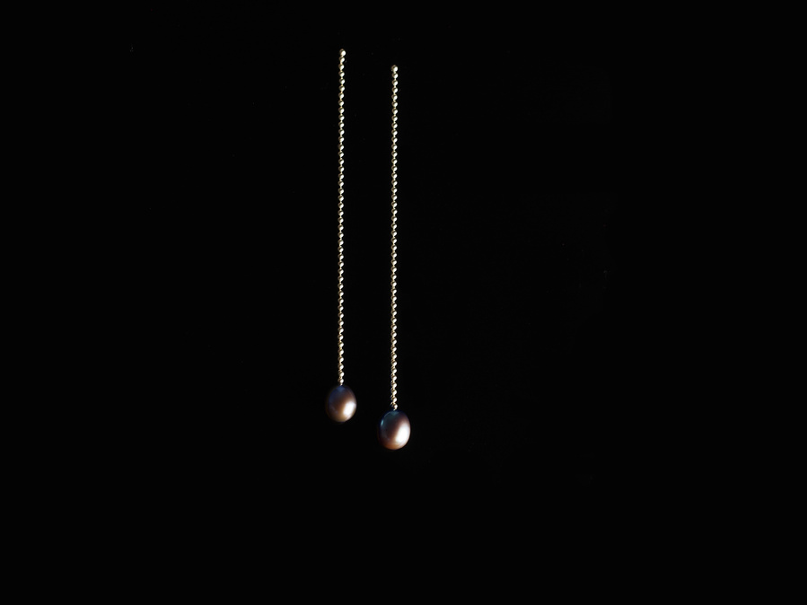 Sterling silver and black freshwater pearl stud dangle earrings entitled K1 P1 Drop Stitch on a black background. Made by contemporary jeweller Di Allison, HALLISON Studios, Tasmania. They feature sterling silver bead/ball chain.