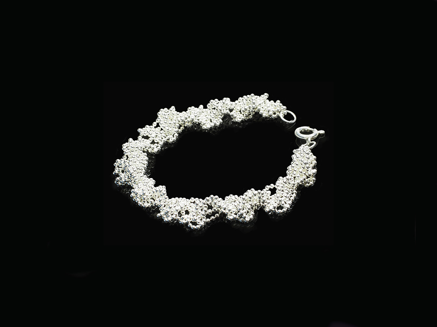 Classic style with a twist: the Twist bracelet in bright sterling silver made by contemporary jeweller Diane Allison, HALLISON Studios, Tasmania, photographed against a black background.