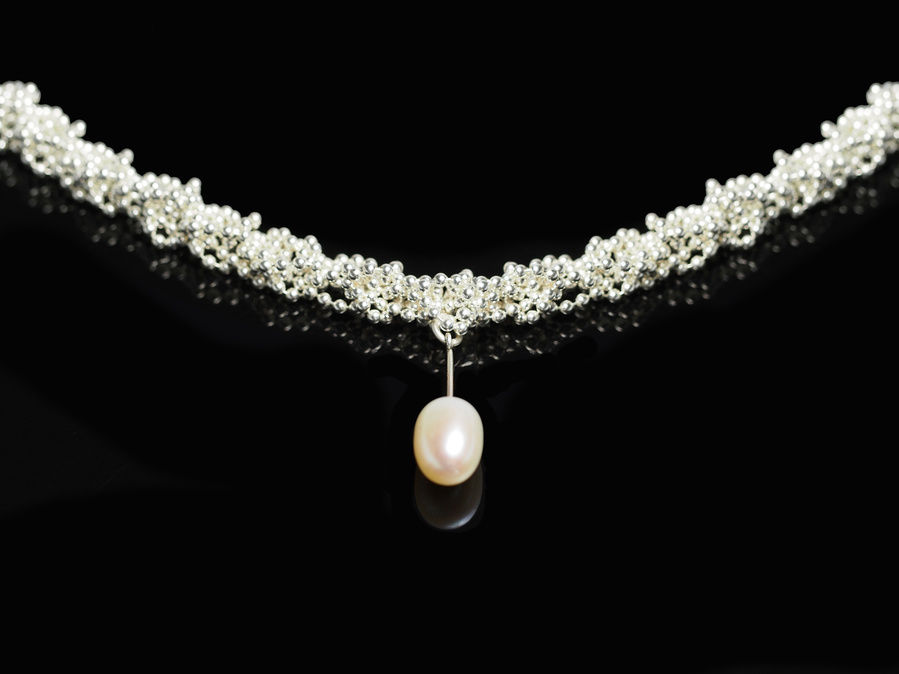 Handmade sterling silver and freshwater pearl necklace on a black background by contemporary jeweller Di Allison of HALLISON Studios, Tasmania, entitled  Knit 1 Purl 1 [K1 P1].