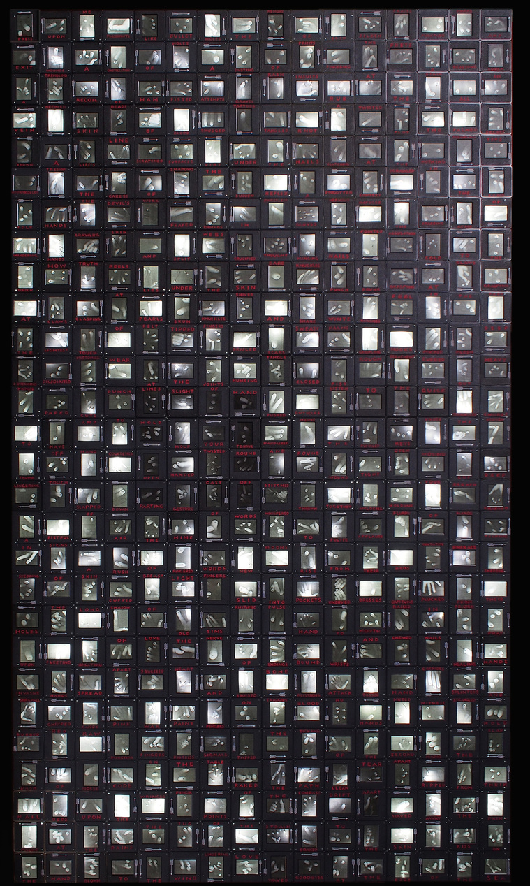 Press Upon Me by Tasmanian contemporary artist Patrick Hall of HALLISON Studios is an illuminated artwork made of 35mm slide mounts containing dozens of images of fingers and pins. Finalist in the Blake Art Prize, 2018.