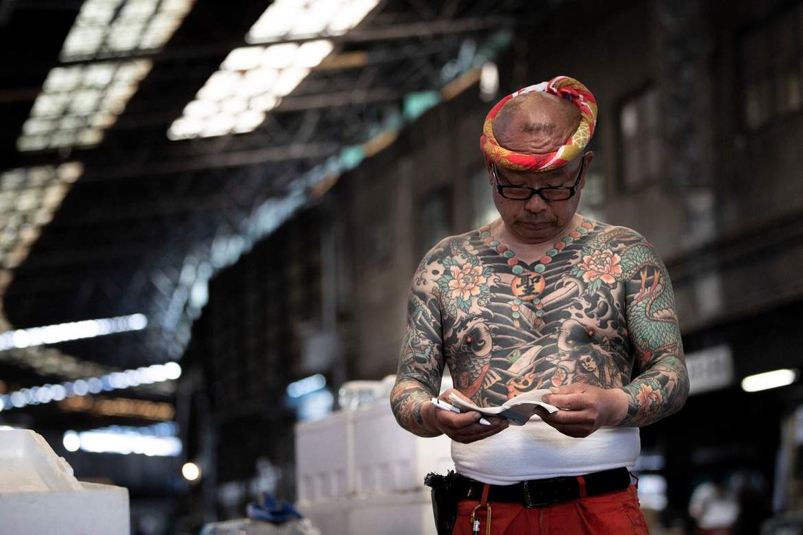 Portrait of tattooed Japanese worker at Tsukiji Fish market in Tokyo Japan. Photography by Darren Gill