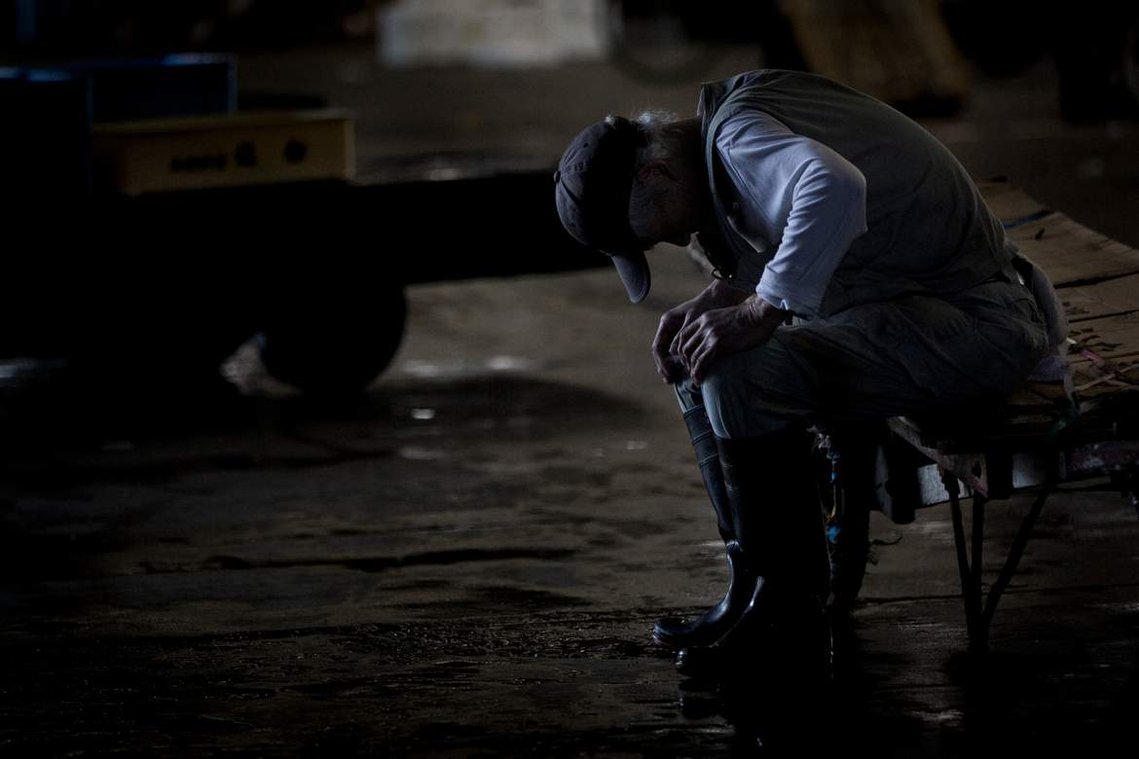 Tired worker at Tsukiji Fish Market in Tokyo Japan. Portrait photography by Darren Gill