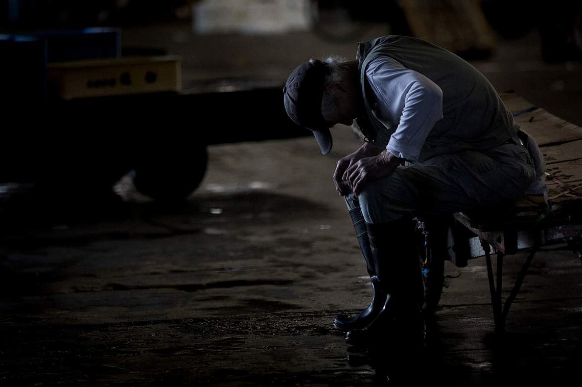 Tired worker at Tsukiji Fish Market in Tokyo Japan. Portrait photography by Darren Gill