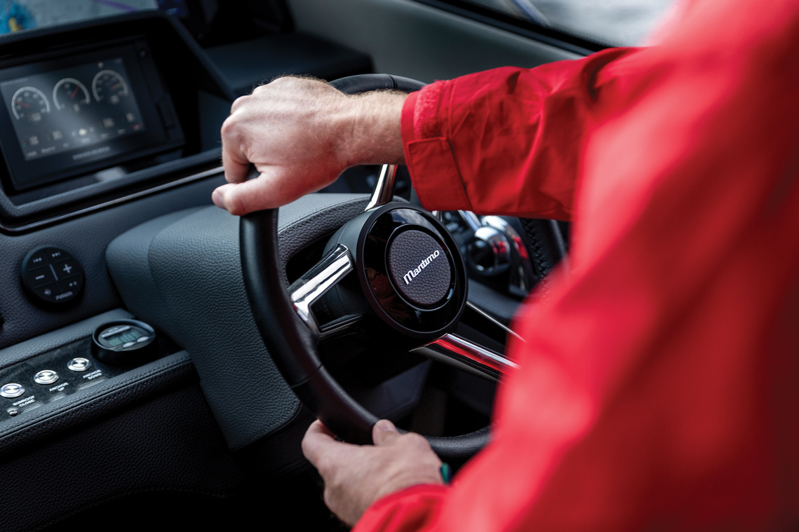 Captain in red jacket steering at the helm of a Maritimo X50 luxury motor yacht