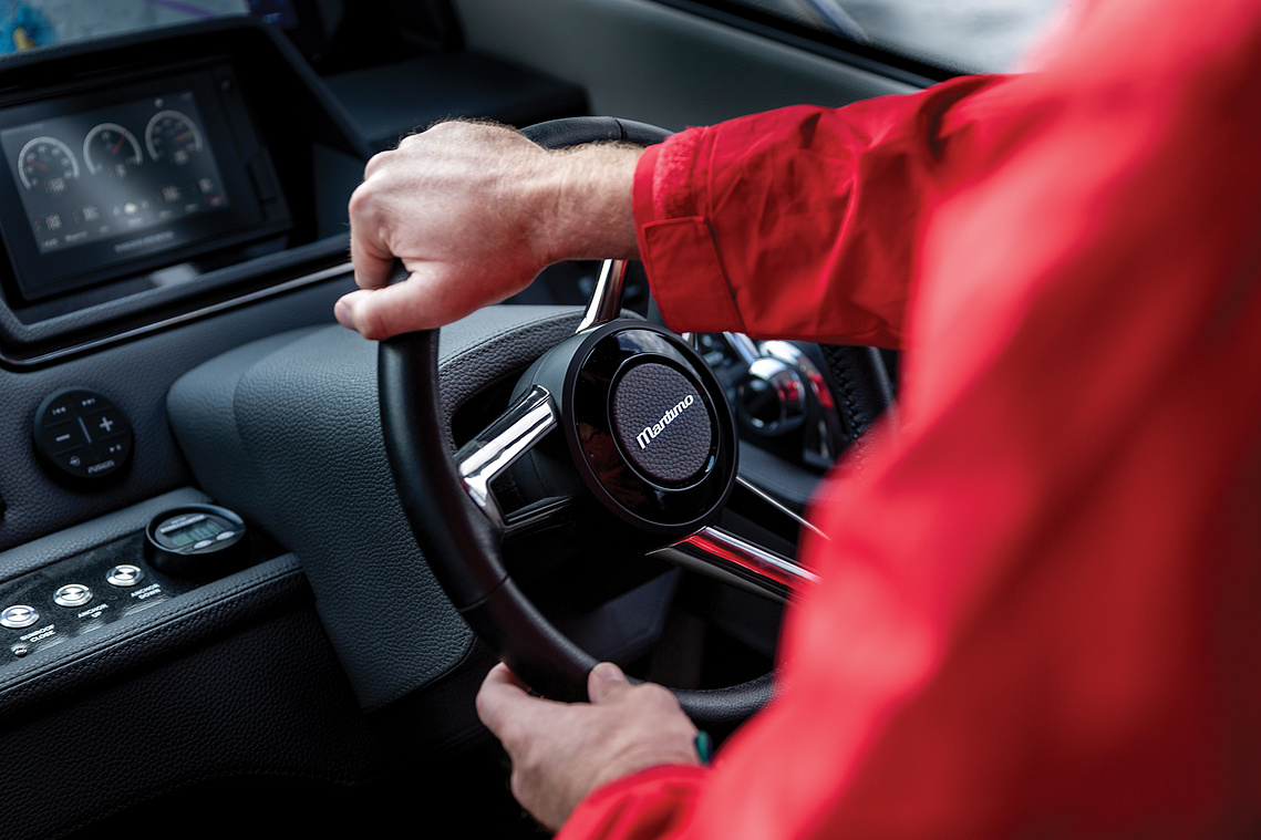 Captain in red jacket steering at the helm of a Maritimo X50 luxury motor yacht