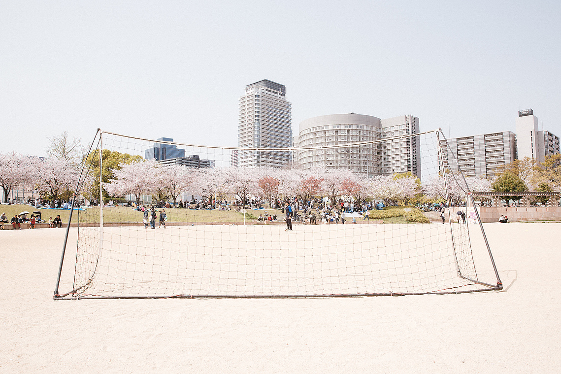 Soccer football pitch park in Osaka, Japan with sakura cherry blossoms and Osaka skyline. Photography by Darren Gill