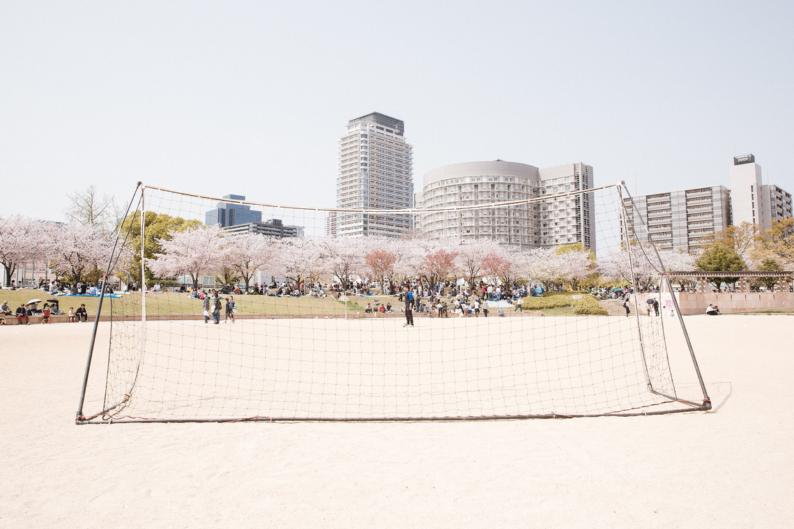 Soccer football pitch park in Osaka, Japan with sakura cherry blossoms and Osaka skyline. Photography by Darren Gill