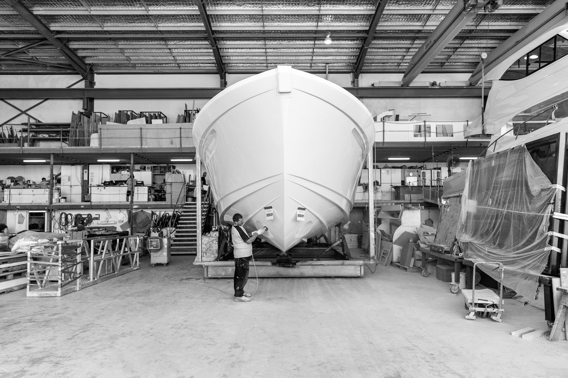 Maritimo Yachts production factory team member sanding a hull in the factory. Photography by Darren Gill