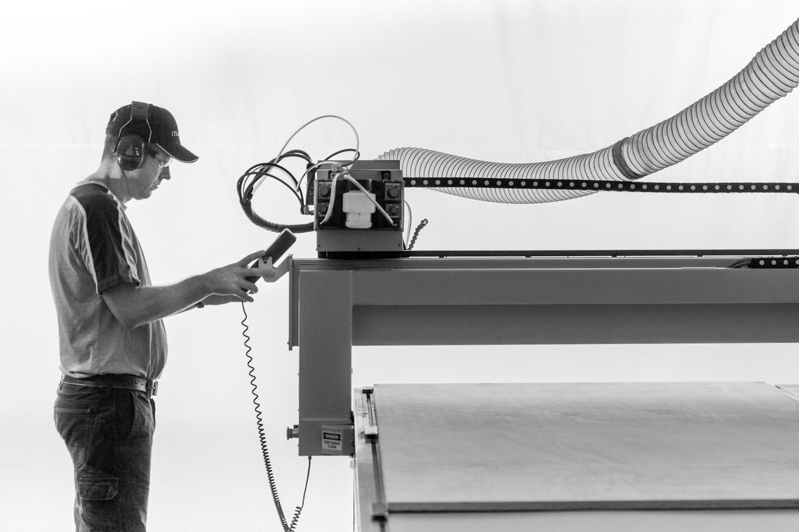 Maritimo Yachts factory worker operating machinery. Photography by Darren Gill