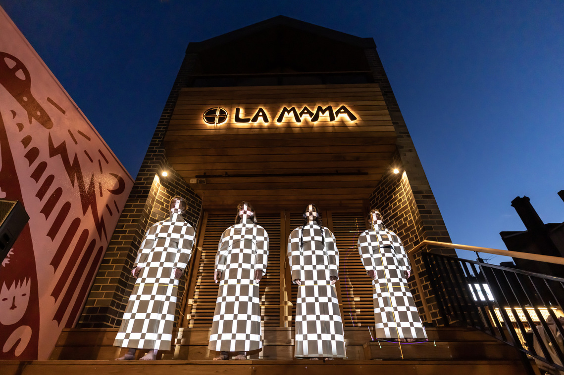 Orli performing on stage with projections in Melbourne at La Mama War-Rak Banksia festival. Photography by Darren Gill