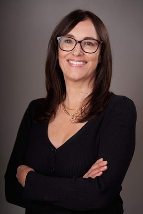 half-length portrait of smiling woman with glasses and long brown hair. Headshot photographer - Clive Allcorn