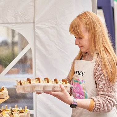 A young woman with a tray of cupcakes. Filling the shelves of her market stall.

Brand Photography by Clive Allcorn