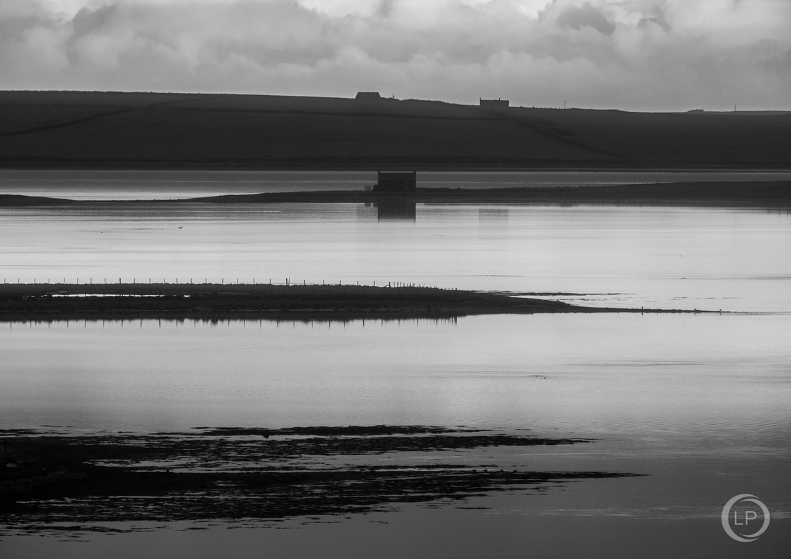 A monochrome photo taken from the LASTlight studio looking down towards the still waters of St Peter's Bay on the East Mainland of Orkney.