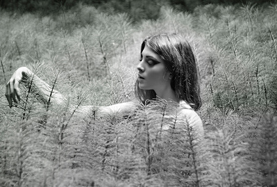 Young white woman sensually playing in a field