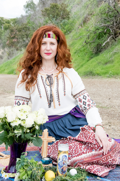 Portrait of a white female healer with red hair sitting in front of her altar