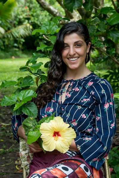 Portrait of a female acupuncturist and doctor in vibrant clothes holding a large tropical flower in Hawaii