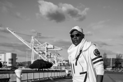 Portrait of a black man in all white in front of iconic Bay Area star wars structures
