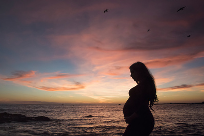 Silhouette of a pregnant woman at sunset