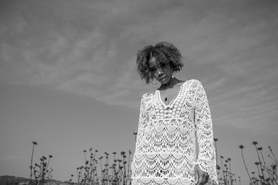 Black and white portrait of a young black woman on an open field
