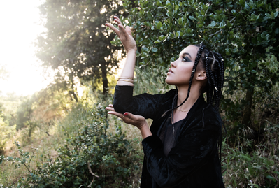 Young black woman with box braids sensually playing outside on a sunny day