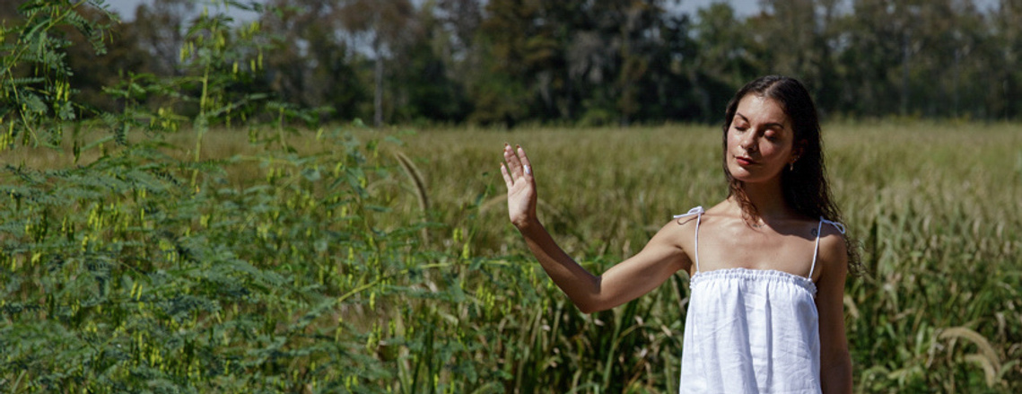 Ev Marquee, a young female healer wearing a white dress in the middle of a field