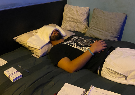 Young male past life regression client laying in bed in hypnosis during an in-home session 