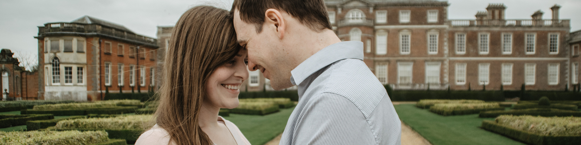 Engagement photos of couple looking at each other in front of country estate