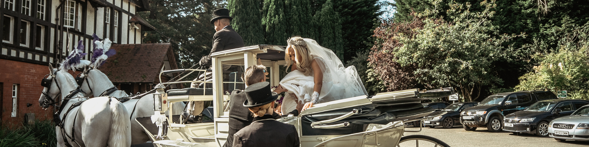 bride getting out of a carriage with horses on wedding day before ceremony