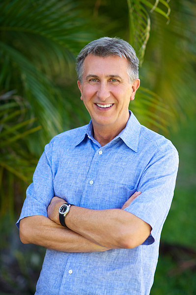 Older salt & pepper haired Executive outdoor Headshot in light blue short sleeve shirt