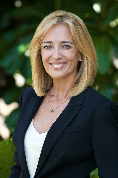 Pretty smiling blonde female realtor Headshot outdoor natural light in dark suit and white cami