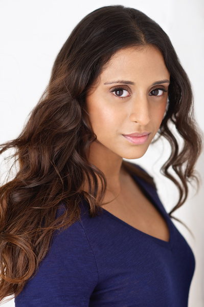 Beautiful latino woman Headshot wearing a dark blue top with a slight smile in her eyes