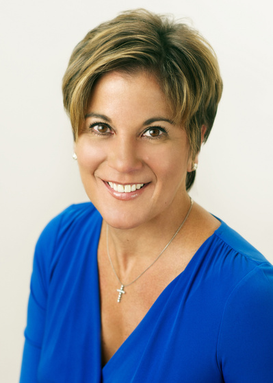 Female Executive Studio smiling headshot in bright blue v neck top