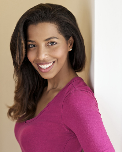 Young Latino, friendly female Studio Headshot in Pink sweater