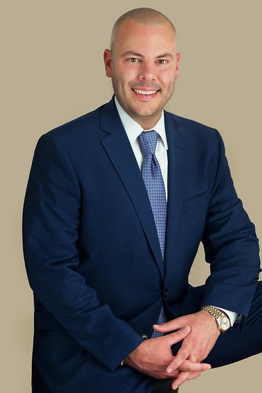 Male Attorney seated and smiling