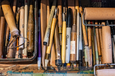 Drawer full of ceramic, wood-handled tools.