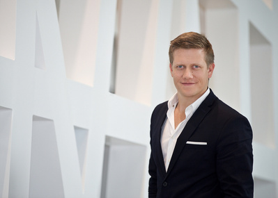 Young Male Executive Environmental  Headshot standing in front of white Art Wall