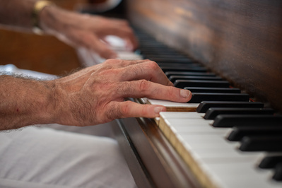 Photo of musicians hands on piano keys, close up
