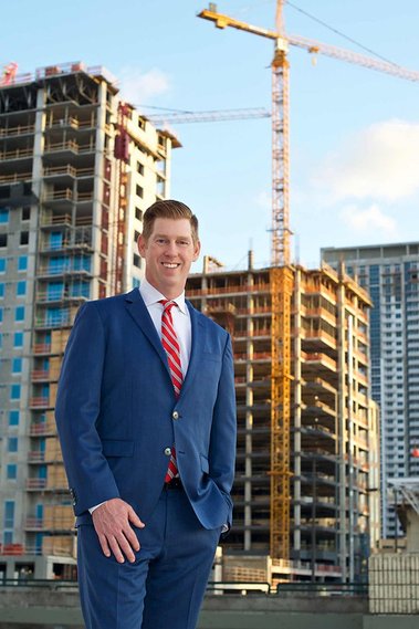 Male attorney with construction site behind him