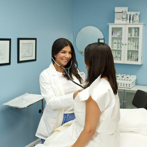 Female doctor checking out a patient in her office